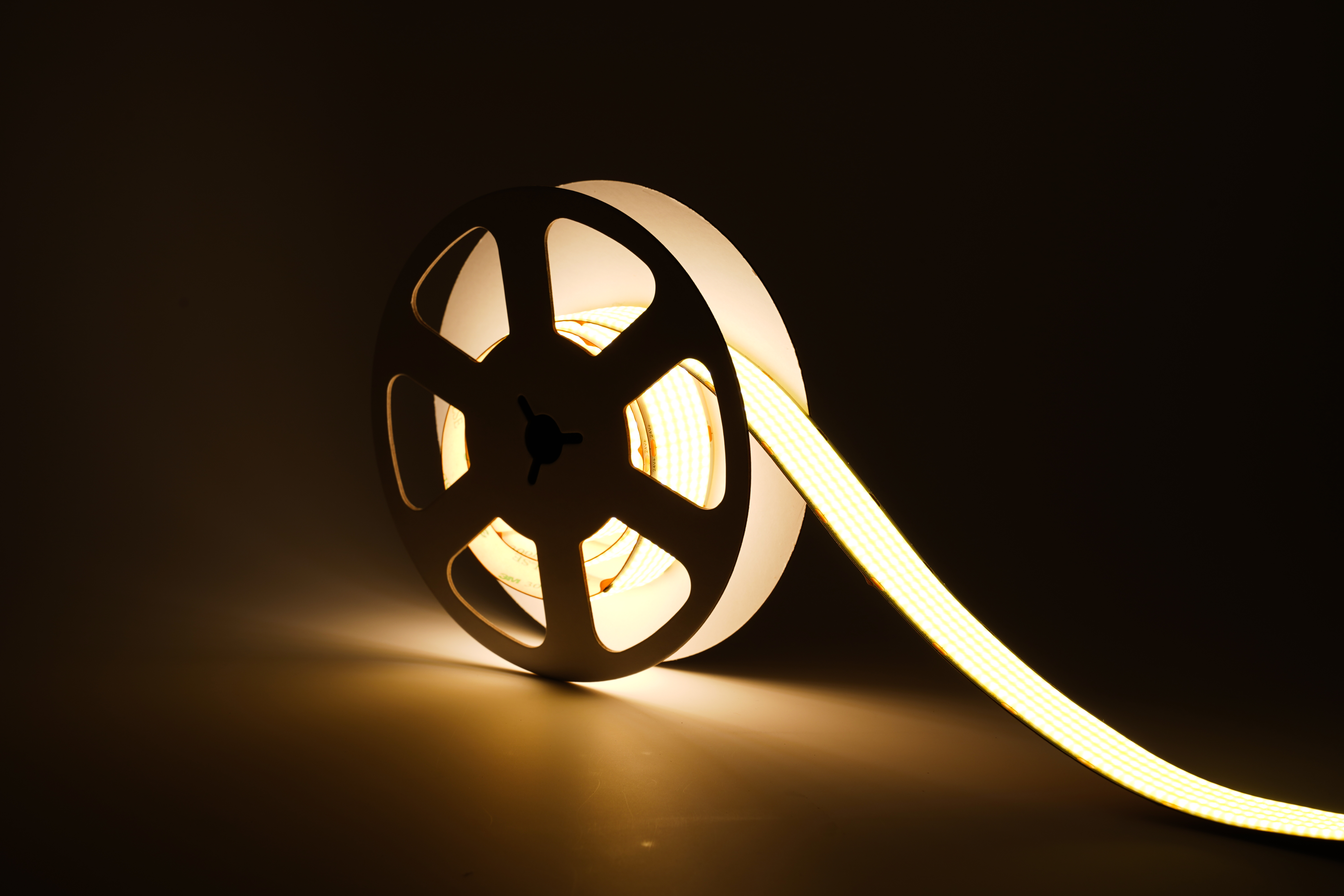 Ultraheller COB LED Streifen 24V mit 1600 LEDs/m und 30 mm Breite, warmweiß leuchtend und teilweise abgerollt – homogenes, punktfreies Licht für professionelle Innenbeleuchtung