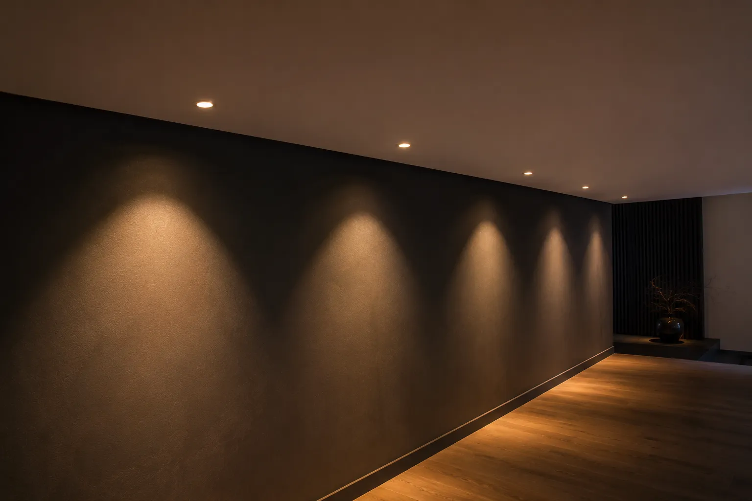 LED Einbauspots – moderne Deckenbeleuchtung mit warmweißem Licht LED Einbauspots mit warmweißen Lichtkegeln an dunkler Wand in moderner Wohnraumdecke
