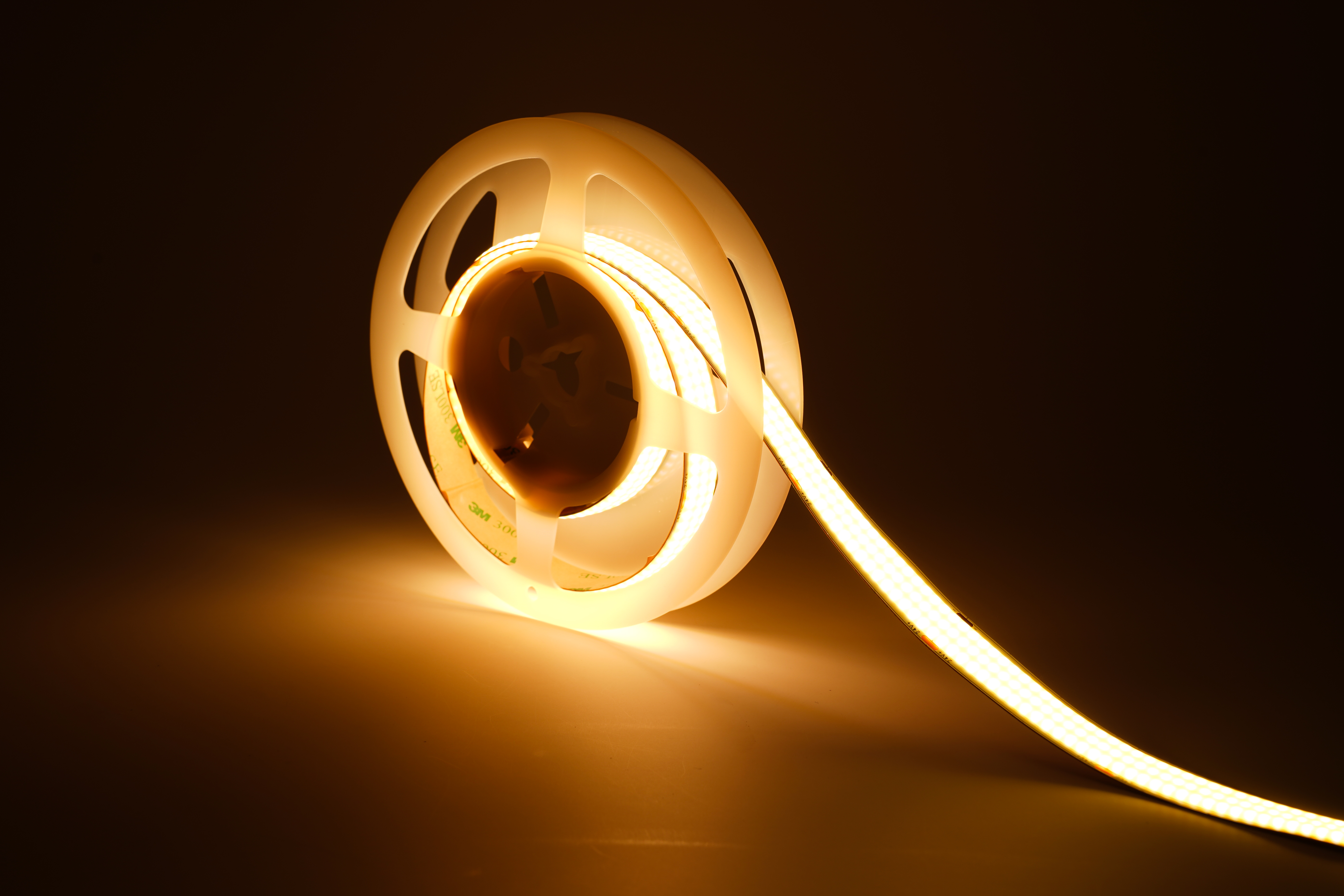 COB LED Streifen 24V mit 960 LEDs/m und 15 mm Breite in warmweißer Beleuchtung – auf Rolle mit abgewickeltem Abschnitt, homogenes und punktfreies Licht für hochwertige Innenbeleuchtung